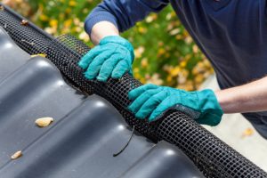 Securing Salem Gutters by worker with gloves on